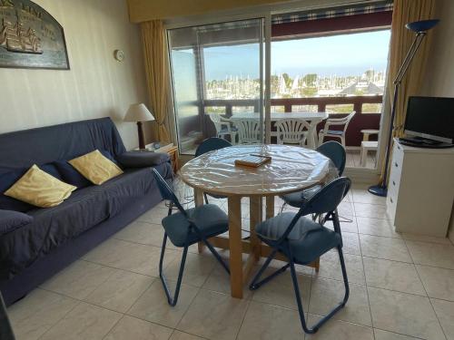 un salon avec une table, des chaises et un canapé dans l'établissement Confortable appartement 4 pers. avec terrasse, piscine et parking à Arzon - FR-1-775-8, à Arzon