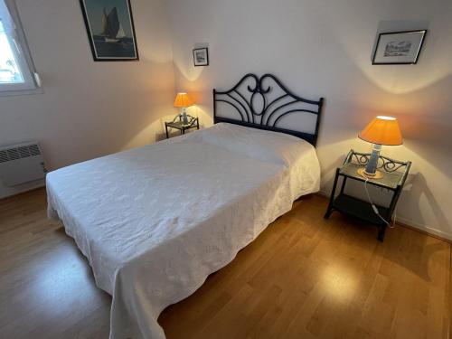 une chambre avec un grand lit blanc avec deux lampes dans l'établissement Confortable appartement 4 pers. avec terrasse, piscine et parking à Arzon - FR-1-775-8, à Arzon
