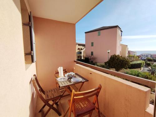 un balcon avec deux chaises et une table sur un balcon dans l'établissement T2 avec Piscine, Parking Privé & Tennis - Proche Plage - 3/4 Pers - FR-1-795-53, à Fleury