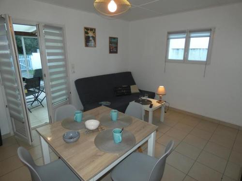 un salon avec une table, des chaises et un canapé dans l'établissement Maison vacances Fromentine 4 pers, véranda, animaux admis, jardin, parking - FR-1-540-309, à La Barre-de-Monts