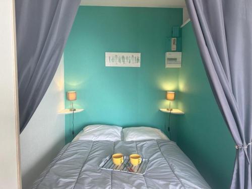 - une chambre bleue dotée d'un lit avec deux lunettes jaunes dans l'établissement Studio face à la mer pour 4, parking, balcon - Notre-Dame-de-Monts - FR-1-540-310, à Notre-Dame-de-Monts