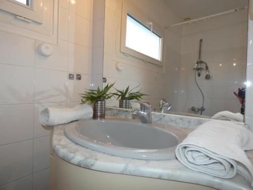 une salle de bain blanche avec un lavabo et un miroir dans l'établissement Maison vacances Fromentine 4 pers, véranda, animaux admis, jardin, parking - FR-1-540-309, à La Barre-de-Monts