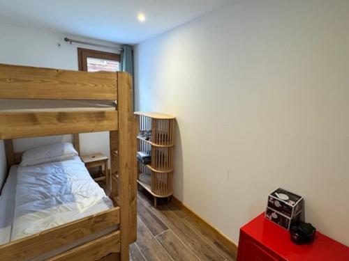 - une chambre avec 2 lits superposés et une table rouge dans l'établissement Charmant appart à 50m des pistes, balcon, parking - FR-1-445-215, à Montgenèvre
