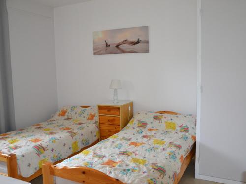 une chambre avec deux lits jumeaux et une commode dans l'établissement T3 jardin à Capbreton, proche plages & commerces, parking, Wifi - FR-1-239-1098, à Capbreton