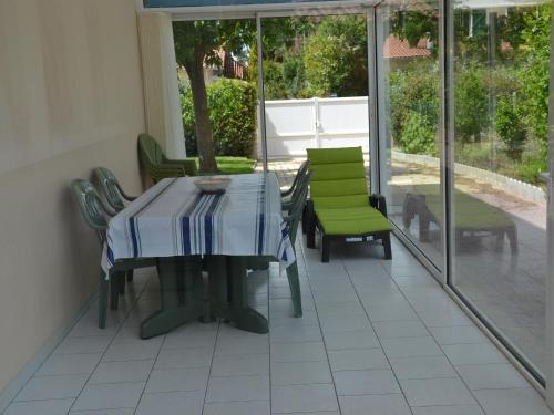- une table et des chaises sur une terrasse avec des portes en verre dans l'établissement T3 jardin à Capbreton, proche plages & commerces, parking, Wifi - FR-1-239-1098, à Capbreton