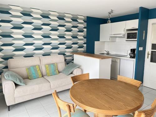 un salon avec un canapé et une table dans l'établissement Studio lumineux près plage, animaux admis, parking privé - FR-1-236-164, à Cucq