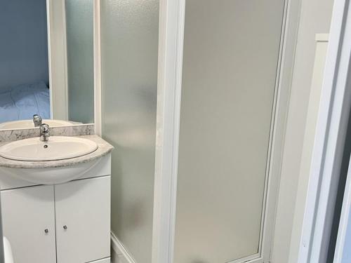 une salle de bain blanche avec un lavabo et un miroir dans l'établissement Studio lumineux près plage, animaux admis, parking privé - FR-1-236-164, à Cucq