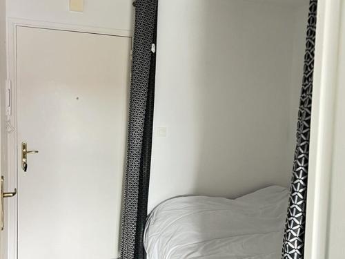 - un miroir à côté d'un lit dans la chambre dans l'établissement Studio lumineux près plage, animaux admis, parking privé - FR-1-236-164, à Cucq