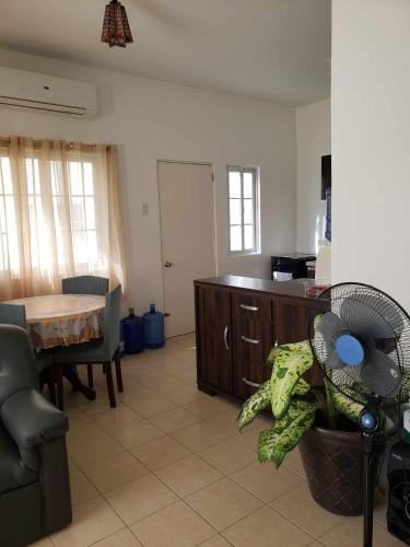 a room with a kitchen with a table and a fan at Hannah & Neil's Place-Panglao in Dao
