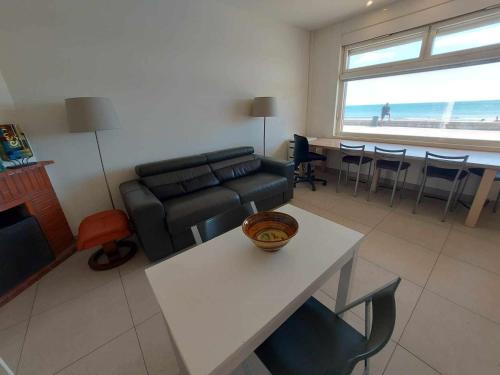 un salon avec un canapé et une table avec des chaises dans l'établissement Appartement 2 pièces climatisé en front de mer pour 4 personnes - FR-1-423-313, au Grau-dʼAgde