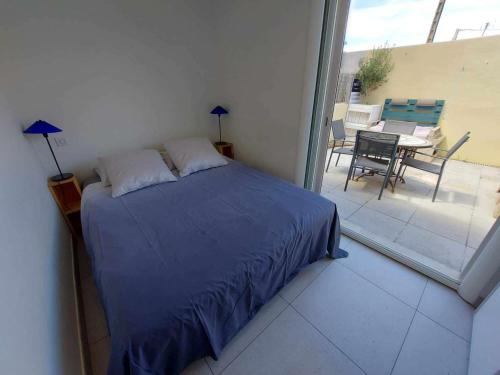- une chambre avec un lit et une terrasse avec une table dans l'établissement Appartement 2 pièces climatisé en front de mer pour 4 personnes - FR-1-423-313, au Grau-dʼAgde