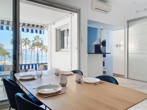 - une table à manger avec des chaises et une vue sur l'océan dans l'établissement Appart. Vue Mer, Climatisé & WiFi à La Ciotat - FR-1-770-41, à La Ciotat