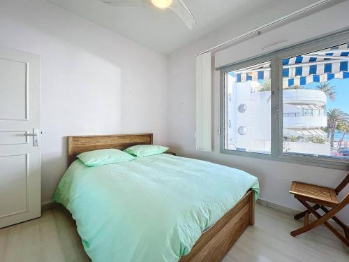 une chambre blanche avec un lit et une fenêtre dans l'établissement Appart. Vue Mer, Climatisé & WiFi à La Ciotat - FR-1-770-41, à La Ciotat