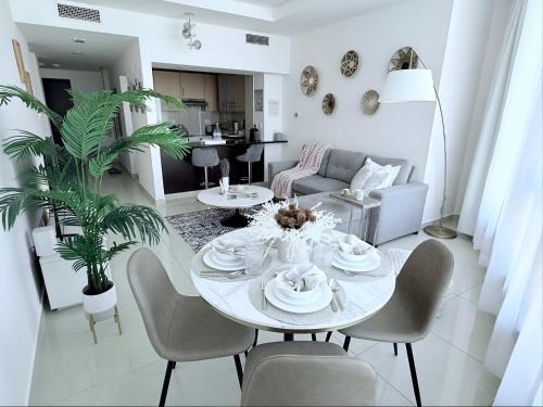a white living room with a table and chairs at Sea Breeze 1BR in Luxury Complex with Sea View Pools Gym on Reem Island in Abu Dhabi