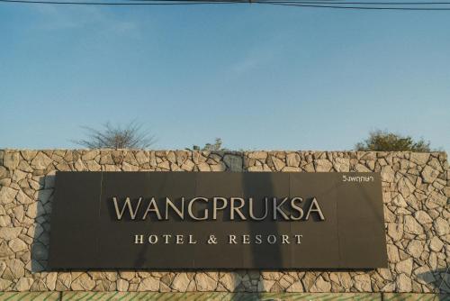 ein Schild für ein Hotel und Resort auf einer Steinmauer in der Unterkunft Wangpruksa Resort in Muaklek