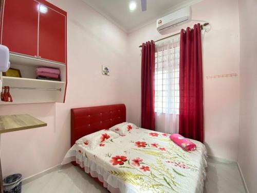 a small bedroom with a bed with flowers on it at D'MENTARI BONDA Homestay Pool in Jertih