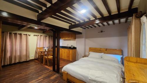 une chambre avec un grand lit et une table dans l'établissement Atithi Bhawan, à Pātan