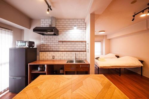 a kitchen with a sink and a bed in a room at TABiTO Stay Inarimachi in Toyama