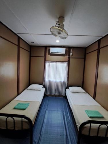a small room with two beds and a window at Benteng Taman Negara in Jerantut