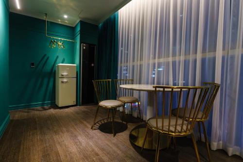 a room with a table and chairs and a refrigerator at Yangju Hotel Ippda in Yangju