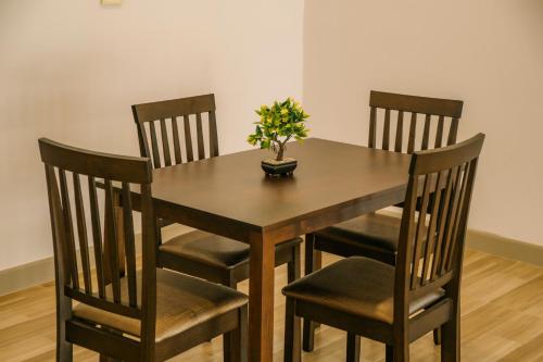 a wooden table with four chairs and a plant on it at Chor Grande Resort in Trat