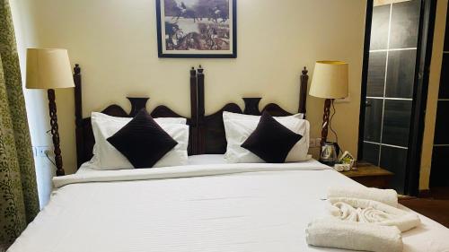 a bedroom with a large bed with white sheets and pillows at Hotel Signature Villa in Jodhpur