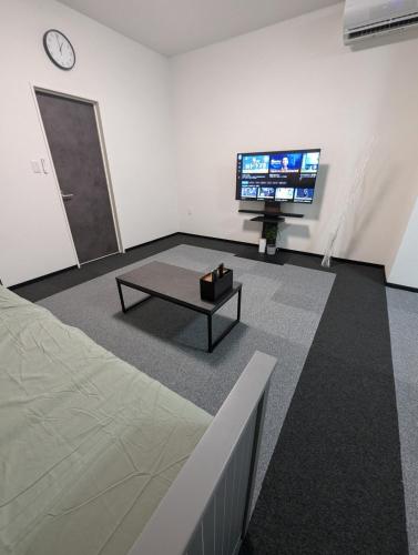 a living room with a tv and a coffee table at DoggoInnn Akita 最大8人で泊れる ペットと泊まれる宿 繁華街まで徒歩3分の好立地 in Akita