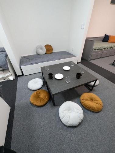 a living room with a table and some pillows at DoggoInnn Akita 最大8人で泊れる ペットと泊まれる宿 繁華街まで徒歩3分の好立地 in Akita