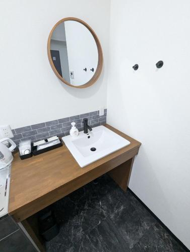 a bathroom with a sink and a mirror at 8人で泊れる ペットと泊まれる宿 DoggoInnn Akita in Akita