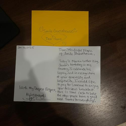 a piece of paper and a yellow note on a table at Smile Guesthouse VangVieng in Vang Vieng