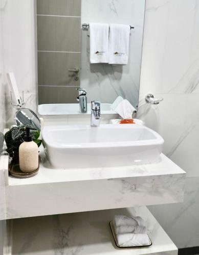 a white bathroom with a sink and a mirror at Sheema Lodge in Hatta