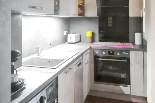 a small kitchen with a sink and a stove at Appartement confortable avec vue sur la mer à Port Leucate, 50 m² in Leucate