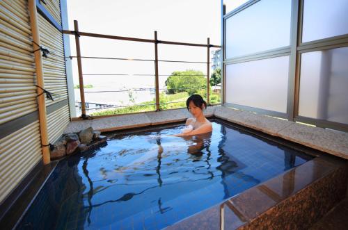 a woman in a swimming pool in a building at Biwako Ryokusuitei in Otsu