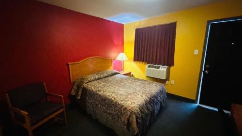 a hotel room with a bed and a chair at Relax Inn by OYO Sulphur Hwy 90 in Sulphur