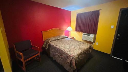 a hotel room with a bed and a chair at Relax Inn by OYO Sulphur Hwy 90 in Sulphur