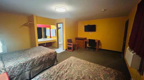 a hotel room with two beds and a desk at Relax Inn by OYO Sulphur Hwy 90 in Sulphur