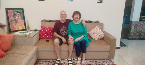 a man and a woman sitting on a couch at Gerards Home stay Fortkochi in Cochin