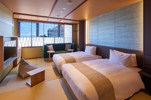 a hotel room with two beds and a window at Biwako Ryokusuitei in Otsu