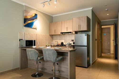 a kitchen with a counter and a refrigerator at Thalassa Seychelles in Beau Vallon