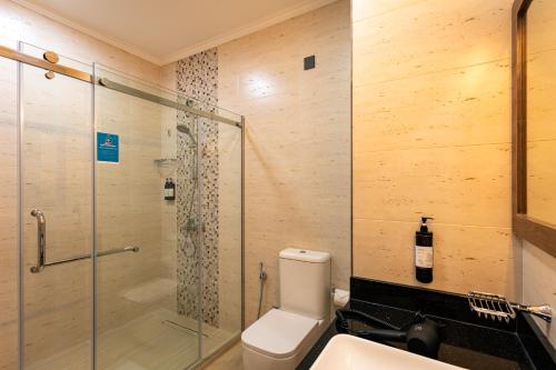 a bathroom with a shower and a toilet and a sink at Thalassa Seychelles in Beau Vallon