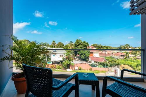 a view from a balcony with two chairs and a table at Thalassa Seychelles in Beau Vallon