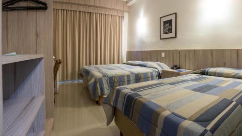 a hotel room with two beds in a room at Hotel Estação 101 - Itajaí in Itajaí