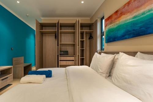a bedroom with a bed with a painting on the wall at Thalassa Seychelles in Beau Vallon