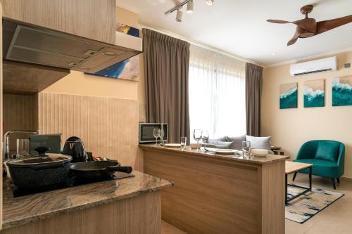a room with a kitchen with a sink and a desk at Thalassa Seychelles in Beau Vallon