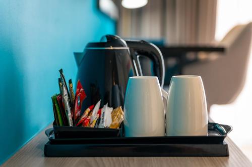 a tray with a tea pot and cups on a table at Thalassa Seychelles in Beau Vallon
