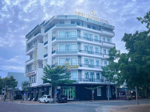 a white building with a sign on top of it at Khách sạn Minh Quang in Phan Rang