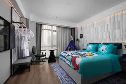 a bedroom with a blue bed and a dressing room at Wanda Moments Nanchang Xihu in Nanchang