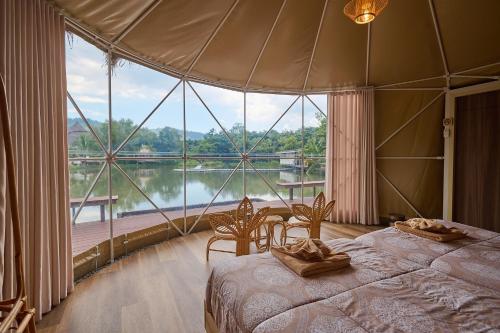 a bedroom with two beds and a large window at Eco Eyes Village in Nakhon Nayok