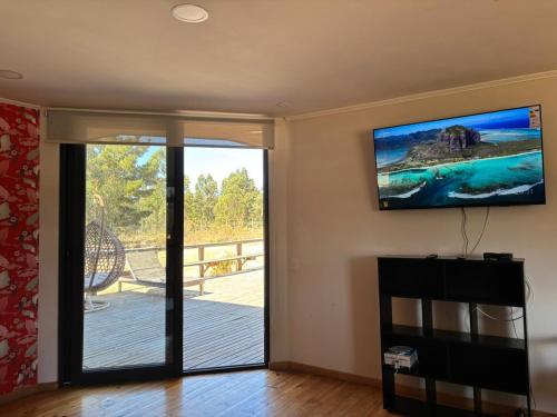 a living room with a sliding glass door to a deck at Hermosa casa en parcela Algarrobo in Algarrobo