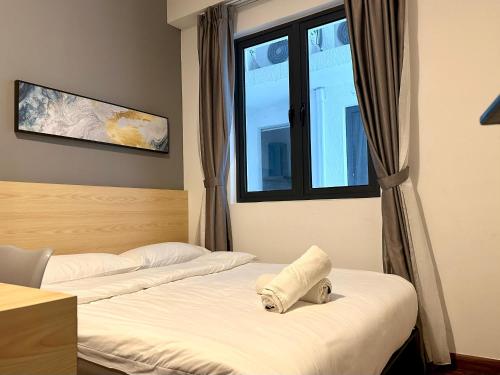 two beds in a hotel room with a window at Kavenue 2-Bedroom City View by CSE in Donggongon